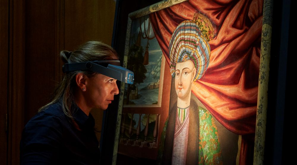 A Royal Collection Trust conservator undertakes final checks before the paintings are installed in the King’s Dining Room.